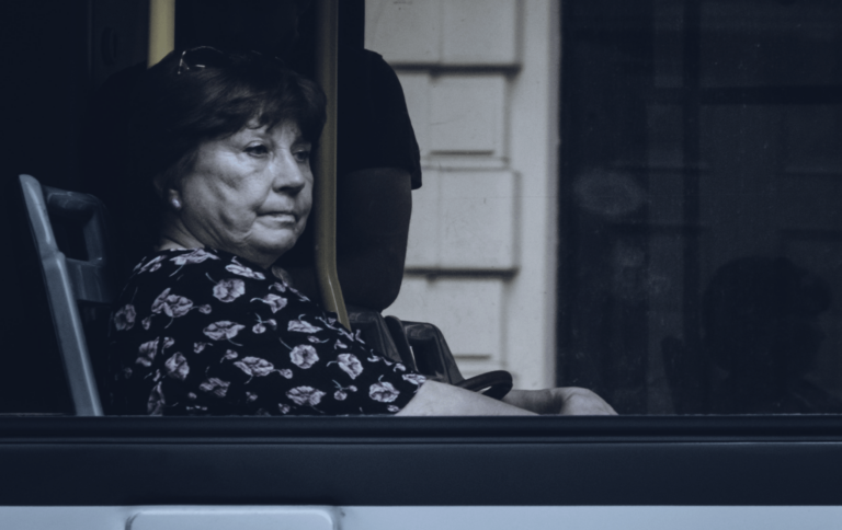 black and white photo of woman sitting alone on bus