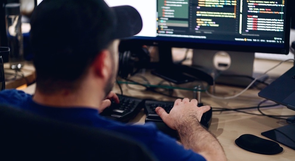 man working on code at computer