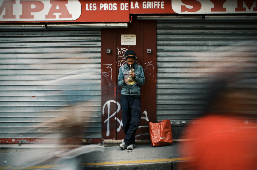 man playing horn on street