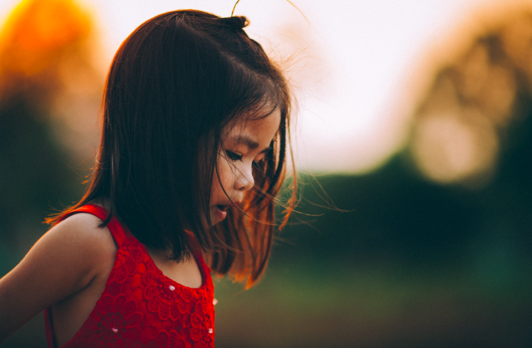 young girl looking down at ground