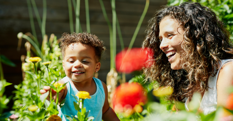 mother and child smiling looking at flowers