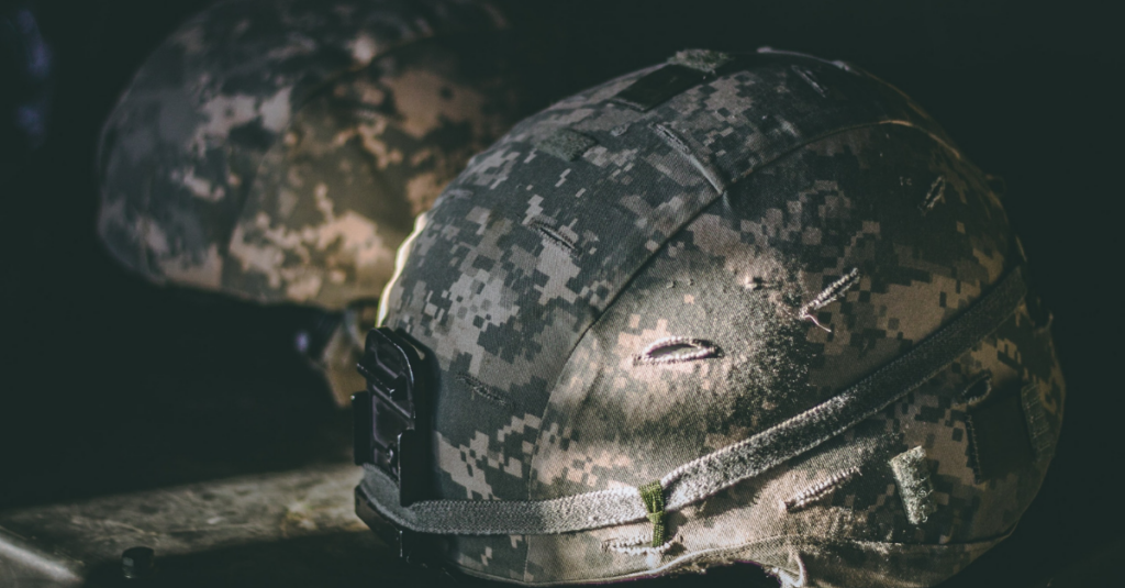 dramatic photo of army helmets in shadow lit by the sun