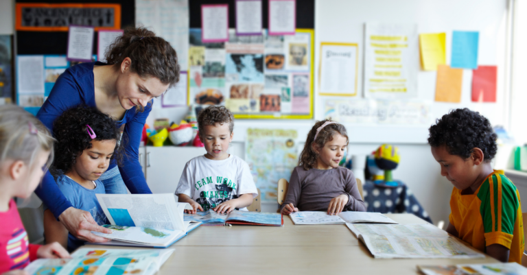 Teacher helps young children with reading