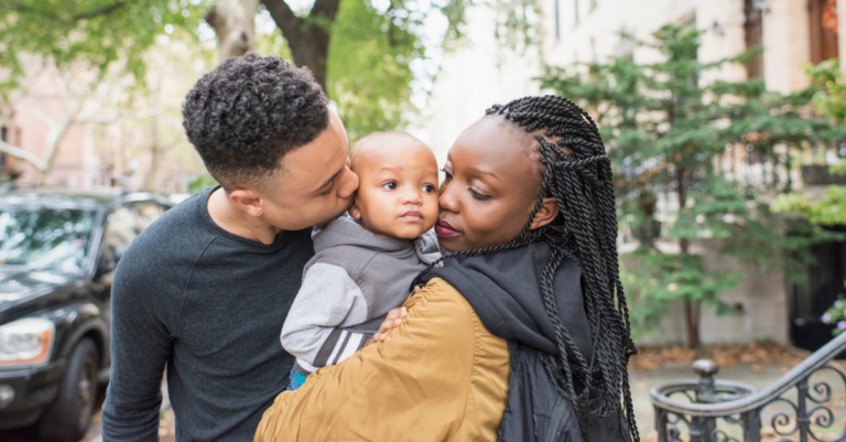 black parents lovingly hold their baby