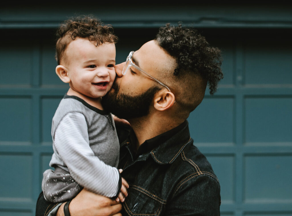 father kissing son on cheek