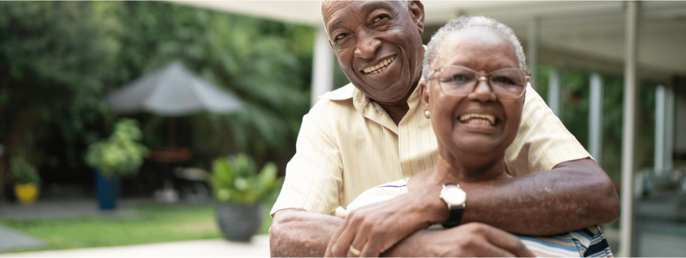elderly couple hugging and smling