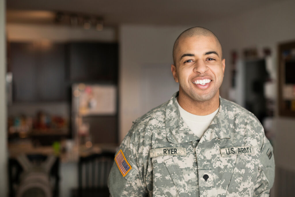 Mixed race military man smiling in living room