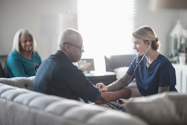 Woman with stethoscope checking mans heart