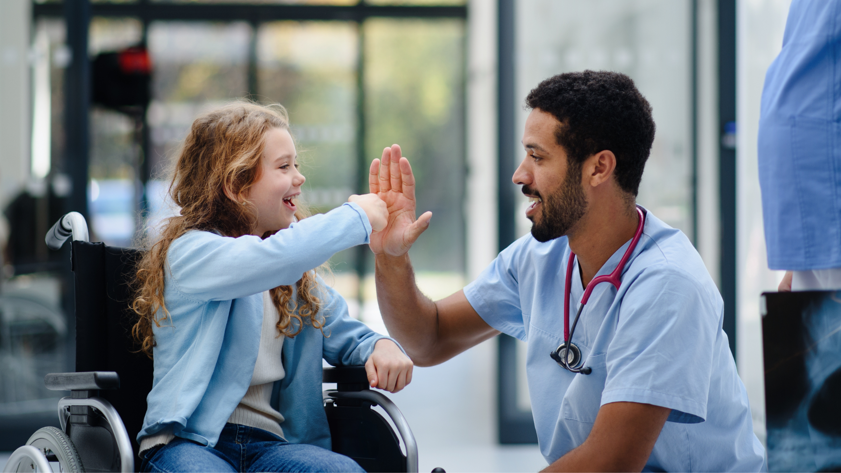 doctor giving girl in wheelchair high five.