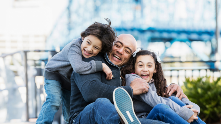 Man sitting and laughing with two young children