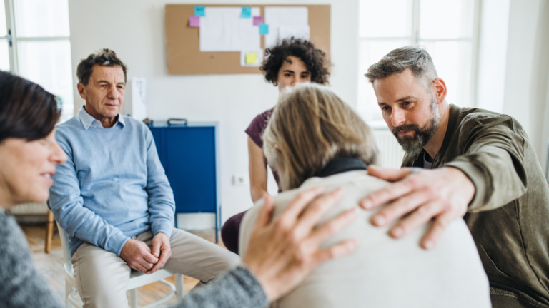 group of people in circle consoling woman