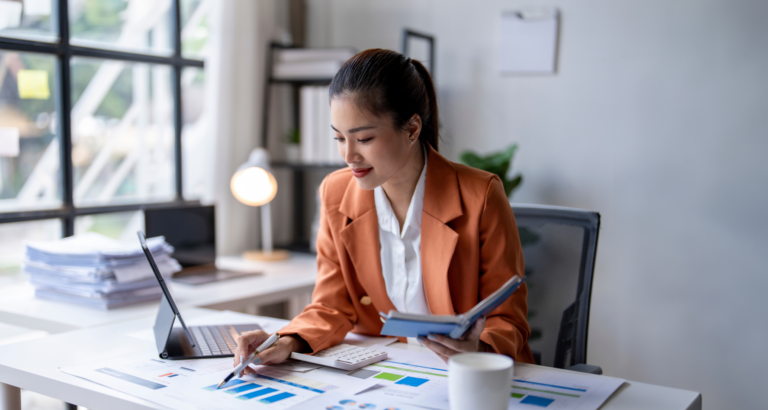Woman at desk looking at charts